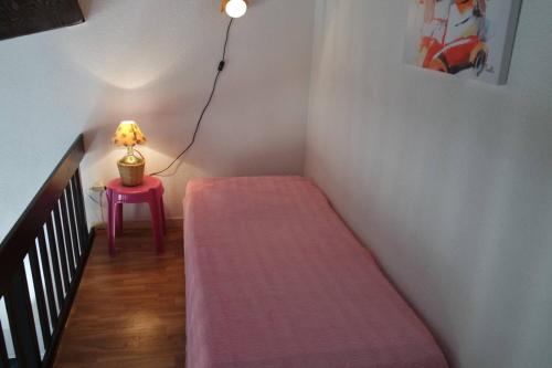 un escalier avec un canapé rose et une lampe sur une table dans l'établissement Pavillon de vacances avec jardin et place de parking - 5REG21, à Saint Cyprien Plage