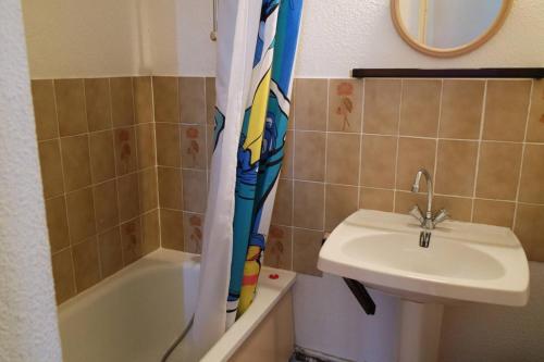 une salle de bain avec un lavabo et un rideau de douche dans l'établissement Pavillon de vacances avec jardin et place de parking - 5REG21, à Saint Cyprien Plage
