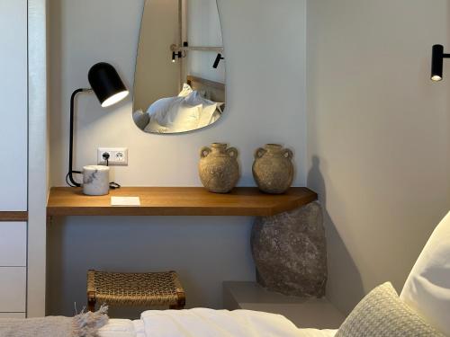 a bedroom with a shelf with a mirror and a bed at Adriana Luxury Villas in Adamas