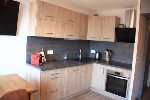 une cuisine avec des armoires en bois et un évier dans l'établissement Joran JR6 MOUNTAIN & NATURE 4 Pers, à Châtel