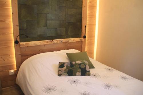 - un lit avec une tête de lit en bois et 2 oreillers dans l'établissement Joran JR6 MOUNTAIN & NATURE 4 Pers, à Châtel