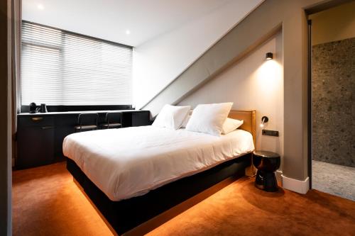 a bedroom with a large white bed in a room at Van der Valk TheaterHotel De Oranjerie in Roermond