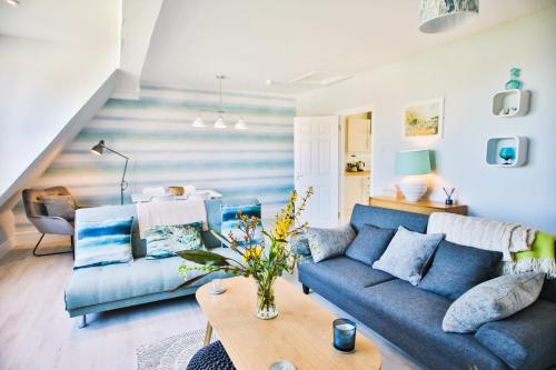 a living room with a blue couch and a table at The Lookout - Hastings in Hastings