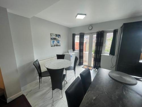 a living room with a table and chairs at Garden Apartment nr Heathrow Airport & Elizabeth Line Train Station with Parking for 2 cars in Hayes