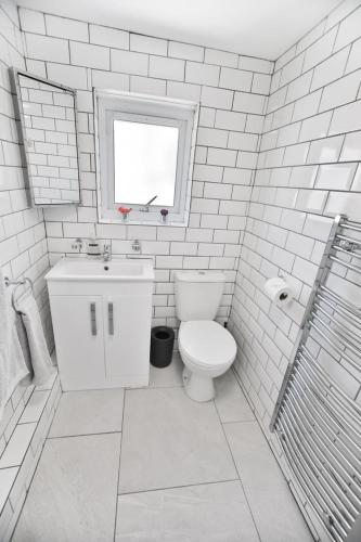 a white bathroom with a toilet and a window at The Lookout - Hastings in Hastings