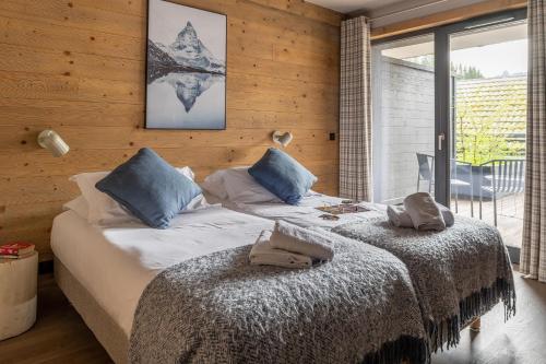 - une chambre avec 2 lits dotés d'oreillers bleus dans l'établissement Apartment 24 - Chalet 1839, aux Gets