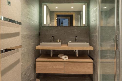 une salle de bain avec deux lavabos et un miroir dans l'établissement Apartment 24 - Chalet 1839, aux Gets