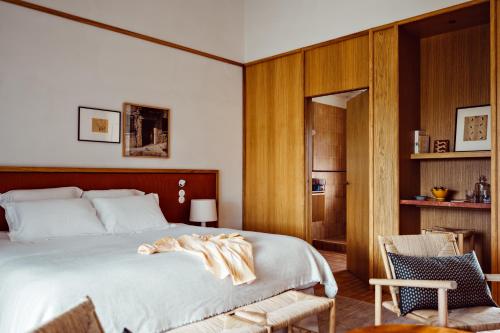 una camera con un grande letto e una sedia di Capelongue, a Beaumier hotel & Spa a Bonnieux
