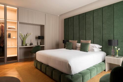 a bedroom with a large bed with a green headboard at Palazzo Venere in Rome