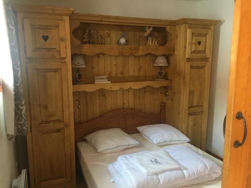 un lit dans une armoire en bois avec deux oreillers dans l'établissement APPARTEMENT MONTAGNE Valmeinier, à Valmeinier