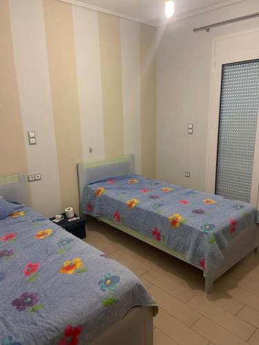 a bedroom with two beds and a door with a window at Luxury villa in leptokarya pierias in Leptokaria