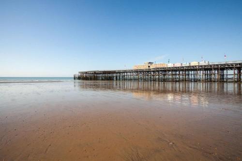 a pier on the beach with the water at 40b Wellington Suites in Hastings