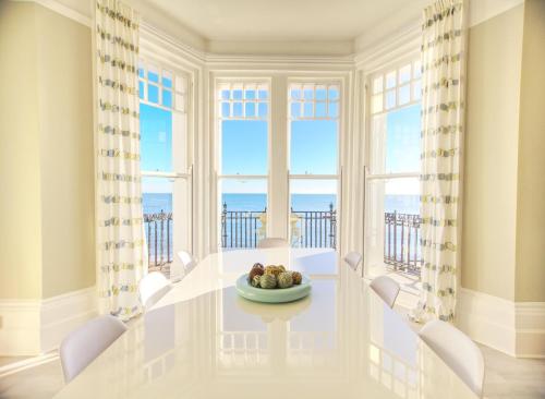 ヘイスティングスにあるThe Palace, Ocean Suiteのダイニングルーム(テーブル、椅子、大きな窓付)