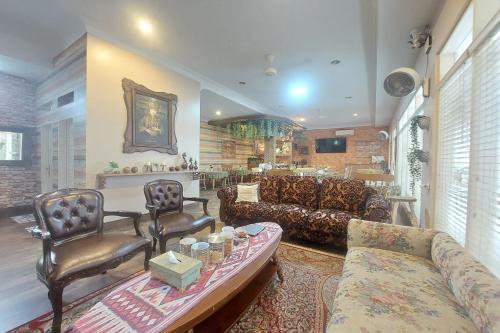 Una gran sala de estar con un sofá y sillas. en Nonie's Huis Hotel, en Medan