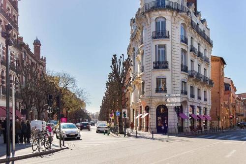 une rue de la ville avec des voitures qui descendent dans une rue dans l'établissement Studio Cozy au cœur des Carmes, à Toulouse