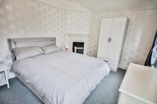 ヘイスティングスにあるThe Penthouse of Palace Courtのベッドルーム(白いベッド1台、キャビネット付)