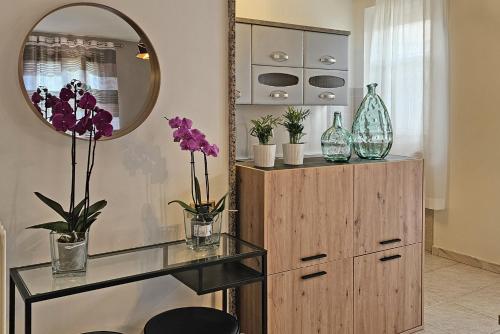 a mirror and a dresser with vases and flowers at il Giardino in Civitanova Marche