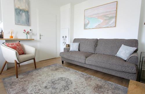 un salon avec un canapé et une chaise dans l'établissement ELBE2 Apartment 8ppl gateways to Disneyland Paris, à Serris