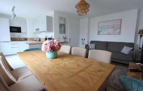 - un salon avec une table en bois et des fleurs dans l'établissement ELBE2 Apartment 8ppl gateways to Disneyland Paris, à Serris