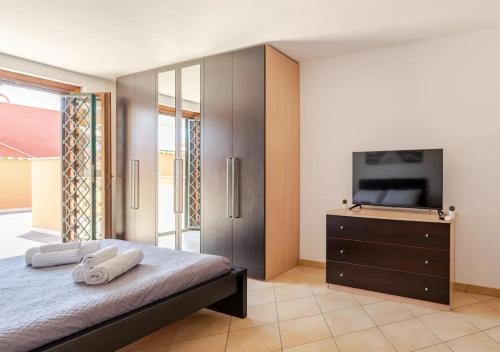 a bedroom with a bed with a tv and a dresser at Big Garden [Free Wi-fi e Netflix] in Fiumicino
