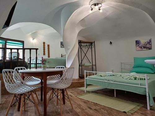 Cette chambre comprend un lit, une table et des chaises. dans l'établissement Хотелски комплекс "ЕЛПИДА'', à Kotel