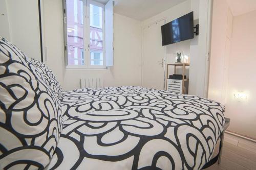 une chambre avec un lit et une télévision dans l'établissement Duplex cosy à Rouen au cœur du centre historique, à Rouen