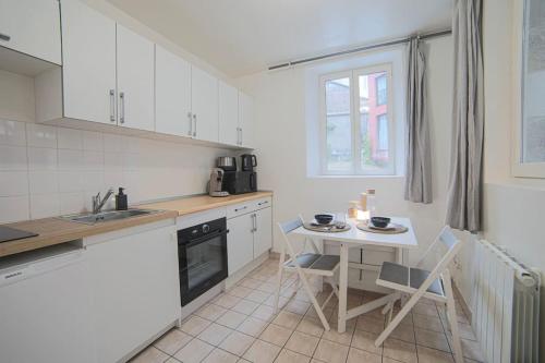 - une cuisine avec une table, une table et des chaises dans l'établissement Duplex cosy à Rouen au cœur du centre historique, à Rouen
