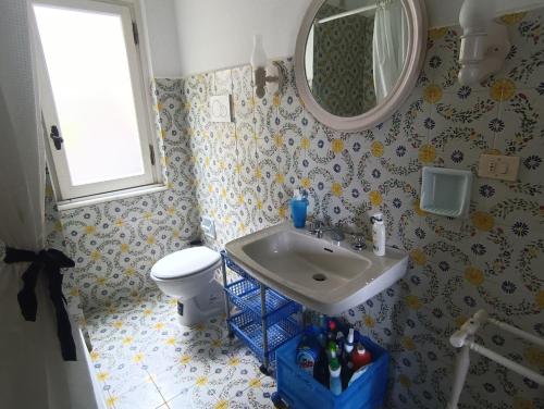 une salle de bain avec un lavabo, des toilettes et un miroir dans l'établissement Galia's beach house, à Zoagli