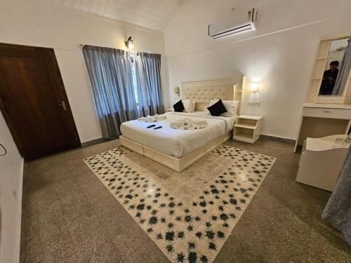 a bedroom with a large bed and a rug at Olive Periyar in Thekkady