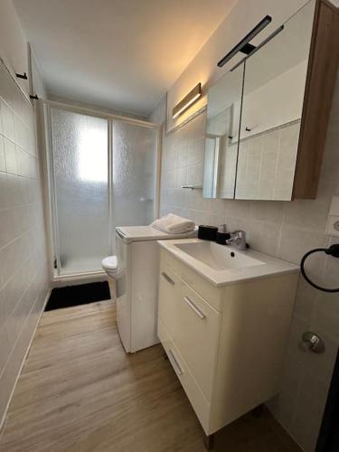 a white bathroom with a sink and a toilet at La Perla de Sa Riera in Begur