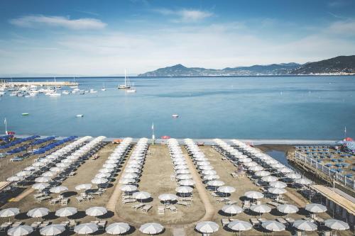 a group of umbrellas on a beach next to the water at Suite Hotel Nettuno in Sestri Levante