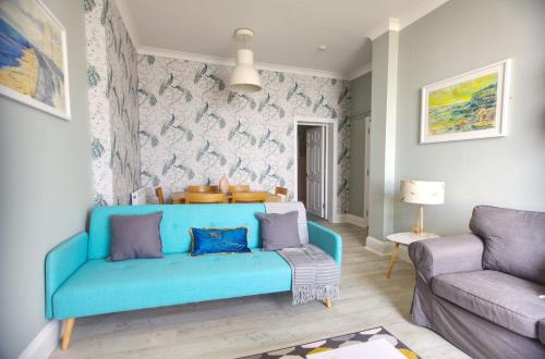 a living room with a blue couch in a room at Sea Mist - Hastings in Hastings