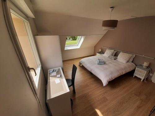 a bedroom with a bed and a desk and a window at Chez Blandine & Pol in Hardelot-Plage
