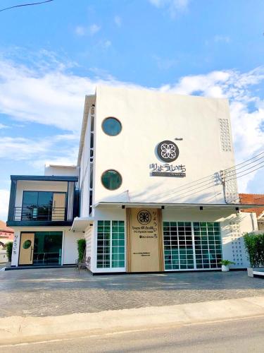a white building with a sign on the side of it at PG Ryoichi Hotel in Chiang Rai