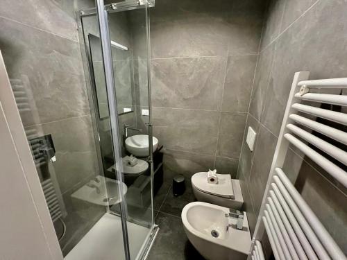 een badkamer met 2 toiletten en een glazen douche bij OASI in Desenzano del Garda