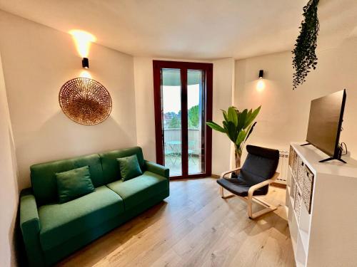 een woonkamer met een groene bank en een stoel bij OASI in Desenzano del Garda