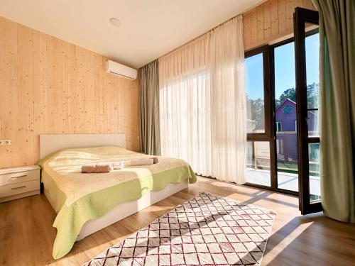 a bedroom with a bed and a large window at VILLA EVA - 5 min to the beach in Shekhvetili