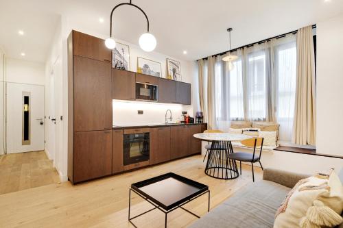 une cuisine et un salon avec un canapé et une table dans l'établissement Pick A Flat's Apartment in Reuilly-Diderot - Rue Claude Tillier, à Paris