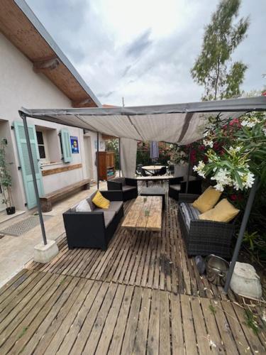 un patio avec des canapés et un parasol sur une terrasse en bois dans l'établissement Bel appartement dans une maison, à Cannes