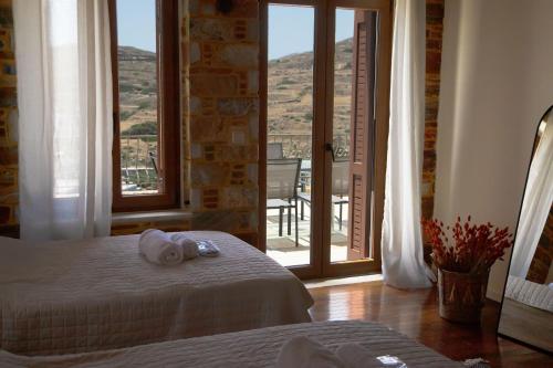 a bedroom with a bed with a view of a balcony at The Stone Project in Ermoupoli