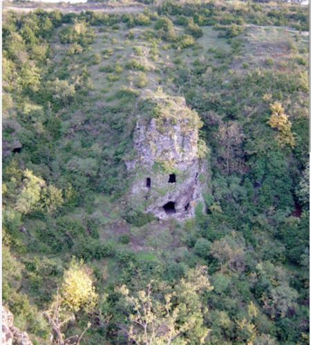 un ancien bâtiment en pierre au milieu d'une forêt dans l'établissement Faites une pause, à Saint-Gineis-en-Coiron