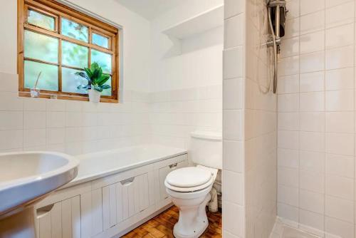 a bathroom with a toilet and a sink and a window at The Writers Retreat- Hastings in Hastings
