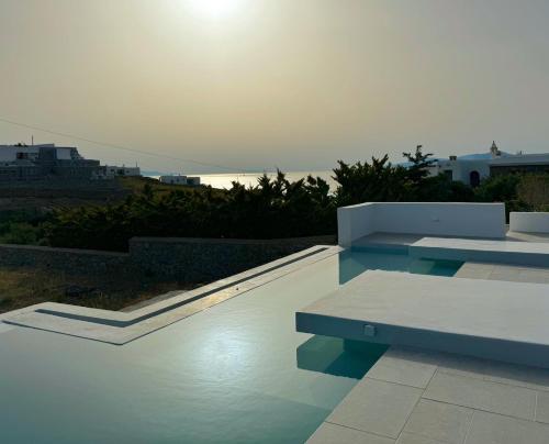a swimming pool with a bench and the ocean at Almond Place in Dexamenes