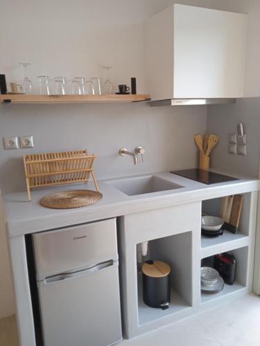a white kitchen with a sink and a counter at Ραχάτι in Áyios Stéfanos