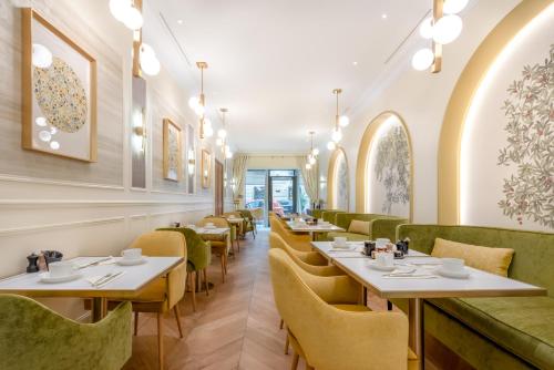 un restaurant avec des tables blanches et des chaises vertes dans l'établissement Hotel Claridge Paris, à Paris