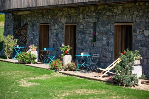 a stone house with tables and chairs in a yard at Les Mazots des Fées in Morzine