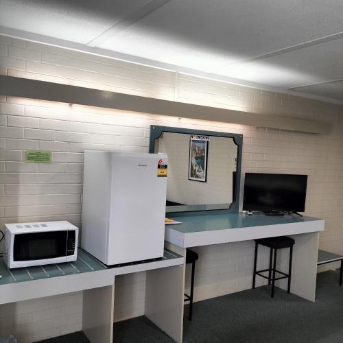 a room with a counter with a microwave and a refrigerator at Wangaratta Motor Inn in Wangaratta