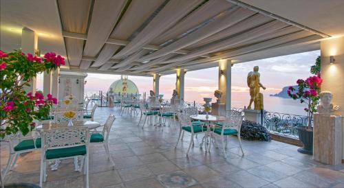 Museum Hotel Antique Roman Palace - Adults Only Ultra All Inclusive في ألانيا: مطعم به طاولات وكراسي ومطل على المحيط