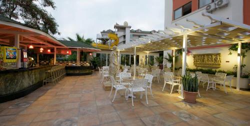 a restaurant with white chairs and tables on a patio at Antique Roman Palace Museum Hotel - Adults Only Ultra All Inclusive in Alanya