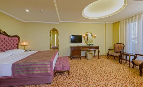 a bedroom with a bed and a desk and a mirror at Antique Roman Palace Museum Hotel - Adults Only Ultra All Inclusive in Alanya